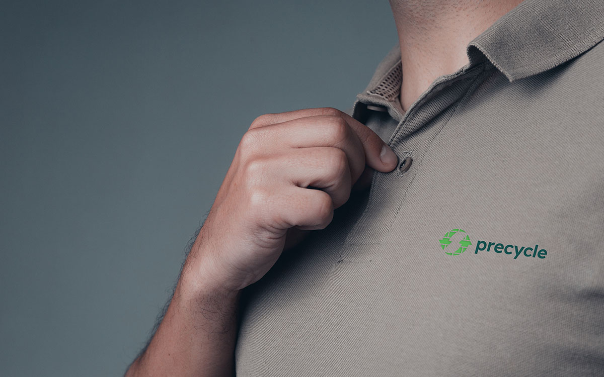 Mockup af profilbeklædning til en brandidentitet for Horsens startup Precycle. Manden har en hånd på knappen, og der er et logo for Precycle på brystet